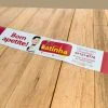 Rótulo Adesivo Personalizado da Marca "Delícias da Latinha" tem o desenho de um homenzinho de roupa de cozinheiro e uma colher na mão, também está escrito "bom apetite" e "lacre de segurança" no rótulo. está sobre uma mesa de madeira.