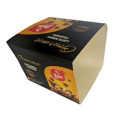 Envoltório de sorvete personalizado da Empresa Maipu, o envoltório é preto, escrito "Gourmet" em dourado, e abaixo do gourmet o sabor do sorvete que é "leite ninho trufado", tem um retângulo arrendondado no canto inferior direito, com o logotipo da Maipu, e abaixo uma bola de sorvete amarela com gotas de chocolate, a bola está caindo dentro de uma calda de chocolate, que está esparramando para cima, na parte superior também tem a mesma foto. O envoltório está fora da embalagem, plástica e é possível ver o interior do envoltório do lado direito.