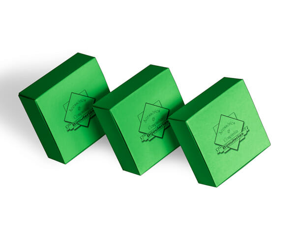 Três caixas quadradas, na cor verde, com o um logotipo quadrado escrito Acessórios e Companhia com uma faixa escrita "bijouterias" logo abaixo.