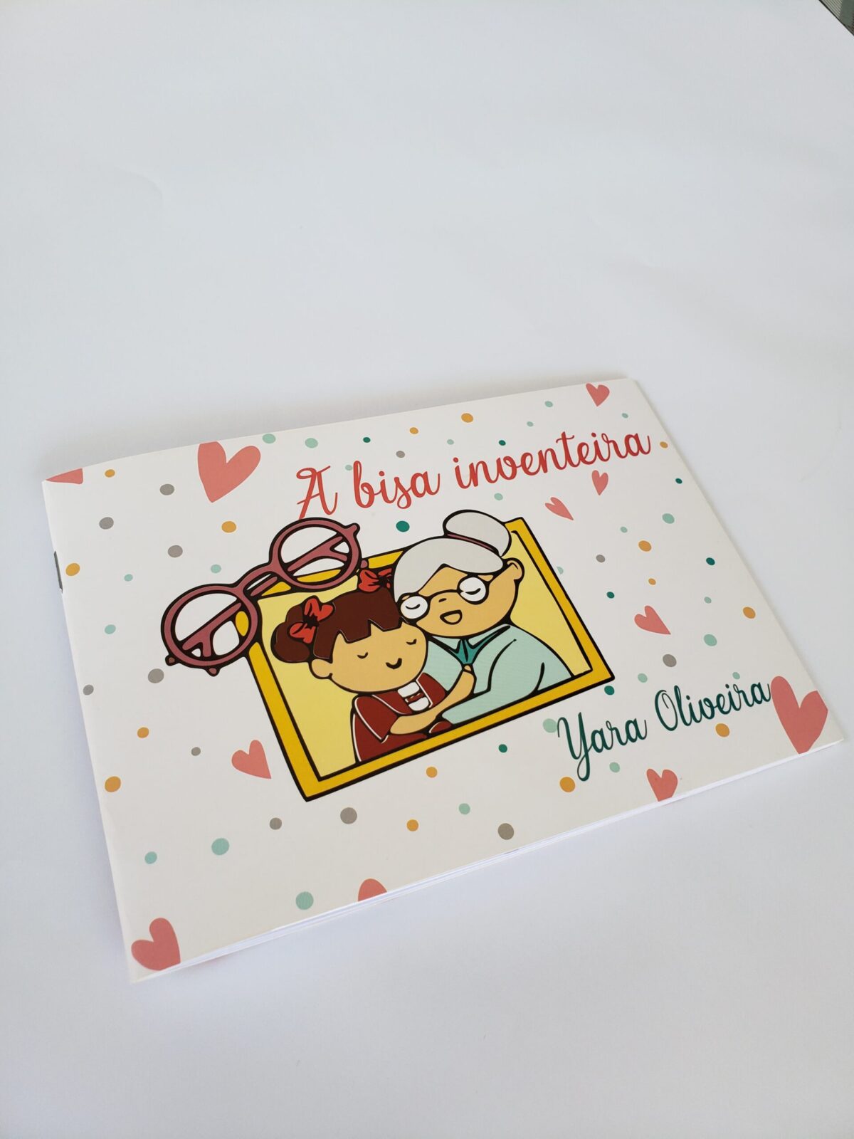 Livro infantil com lombada canoa sobre mesa om fundo branco, título 