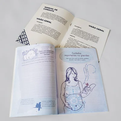 dois livros abertos mostrando o miolo um deles predominante azul e o outro branco com fechamento em grampo e lombada canoa