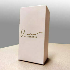 Caixa de perfume personalizada sobre uma mesa marrom com fundo cinza