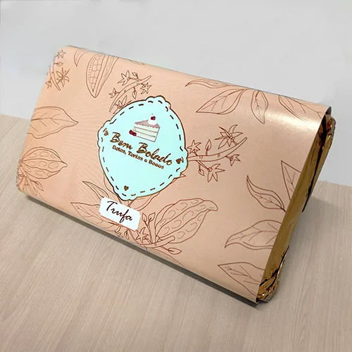 Rótulo personalizado para Chocolate com Aplicação Especial de Hot Stamping para= com um fundo cinza sobre uma mesa de madeira