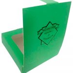 Uma caixa quadrada aberta, mostrando majoritariamente as costas da embalagem, porém tem um pedacinho da parte de dentro da caixa sendo mostrada na lateral esquerda da foto. A embalagem é verde com o logotipo 
