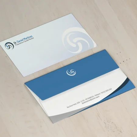 Envelope Ofício Personalizado - Dois envelopes representando frente e verso com detalhe azul e azul claro sobre uma mesa de madeira