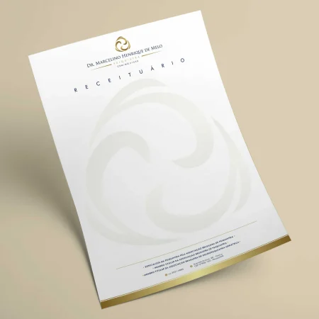 Receituário Personalizado - A4 em Sulfite 90g – MOD. 002 - Receituário branco com detalhes em dourado na base com uma logomarca grande em marca dágua sobre um fundo bege
